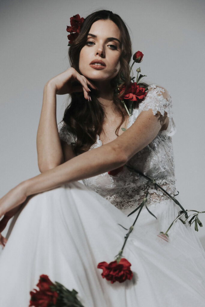 femme avec une robe de mariée et des roses rouges