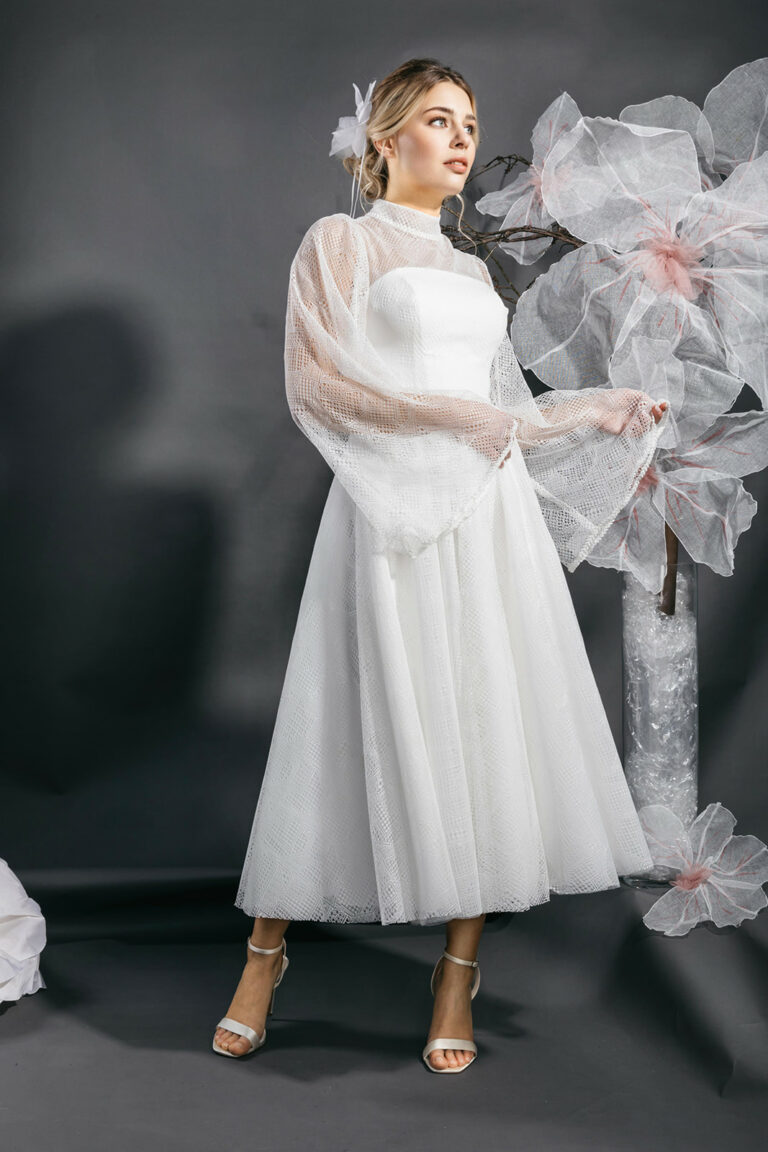 femme dans une robe de mariée midi bohème à manches