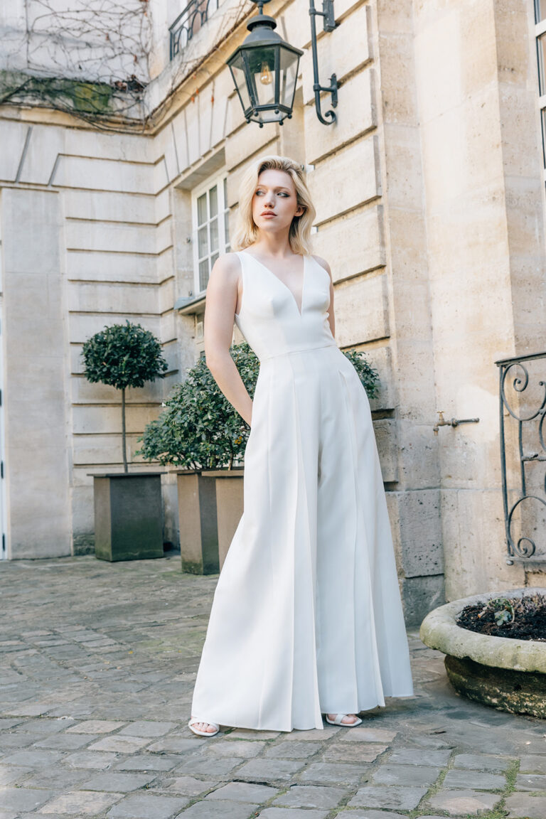 Femme vêtue d'une combinaison de mariée blanche et élégante.