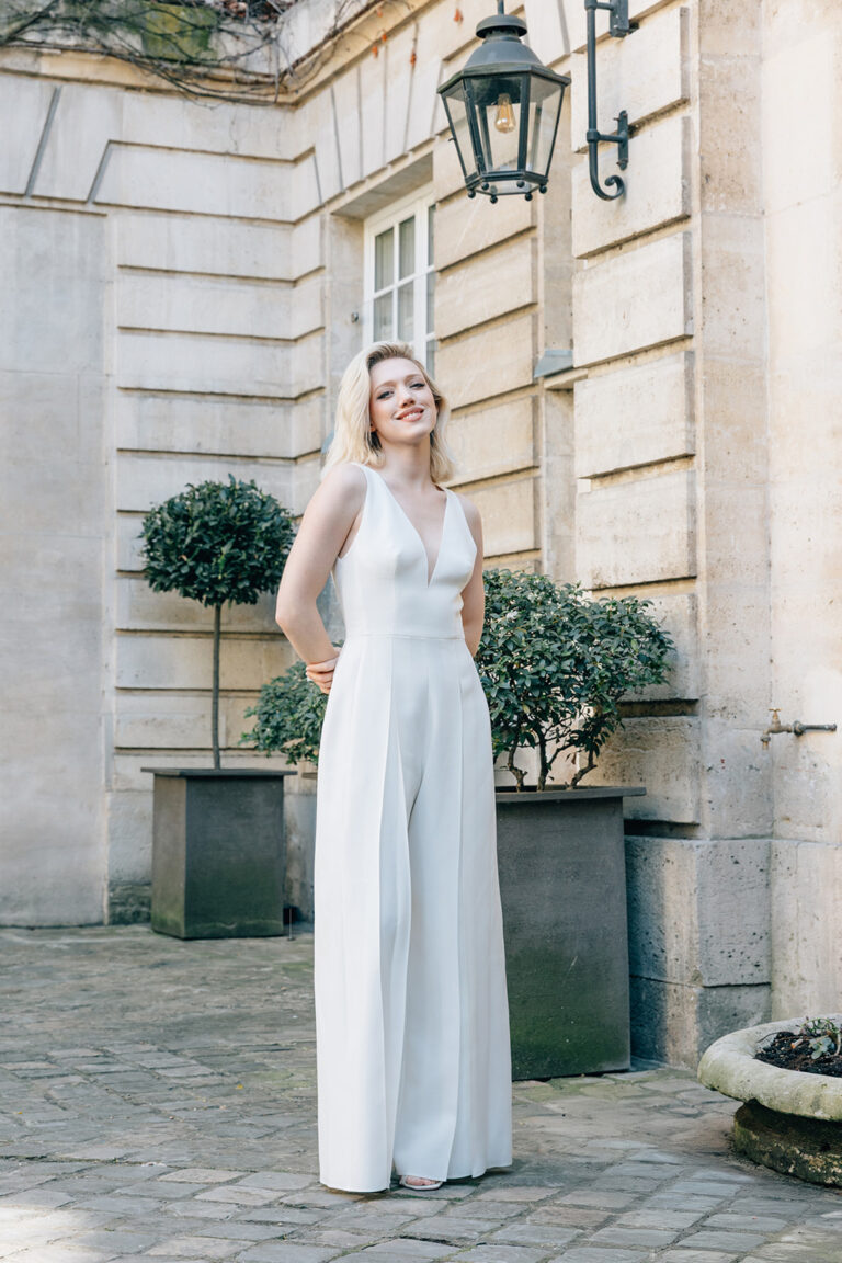 Femme vêtue d'une combinaison de mariée blanche et élégante.