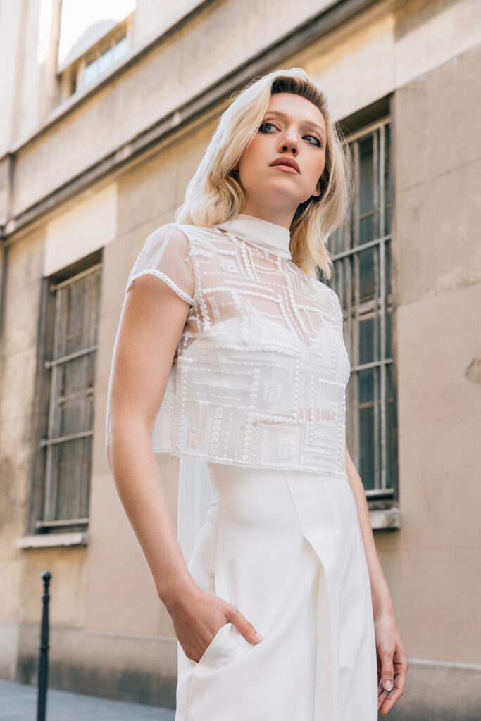 Femme portant une tenue de mariée blanche avec un pantalon et un top en tulle brodé