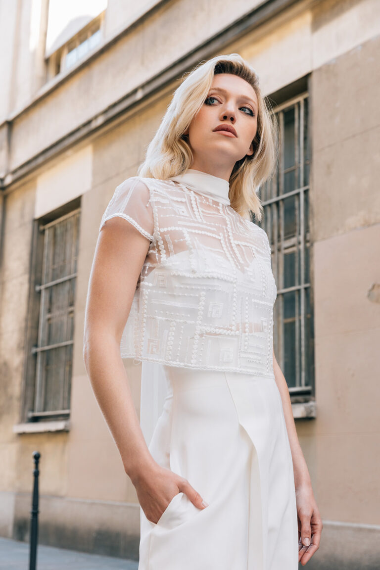Femme portant une tenue de mariée blanche avec un pantalon et un top en tulle brodé