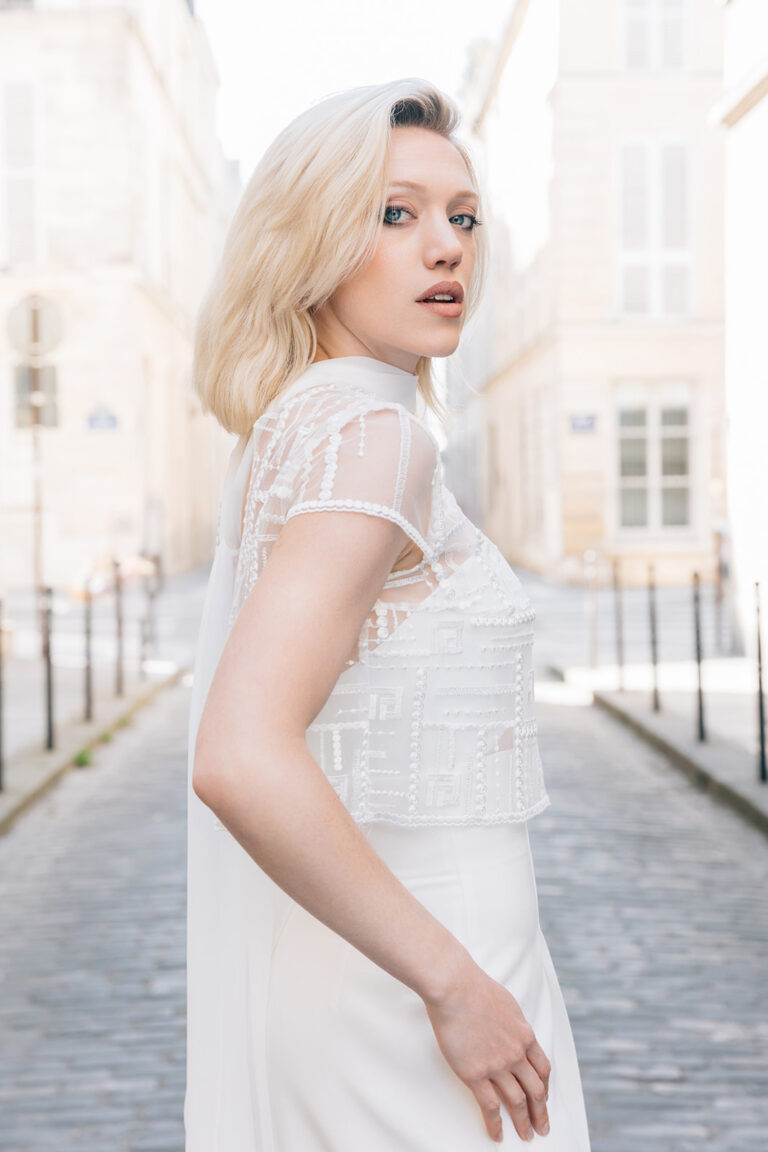 Femme portant une tenue de mariée blanche avec un pantalon et un top en tulle brodé