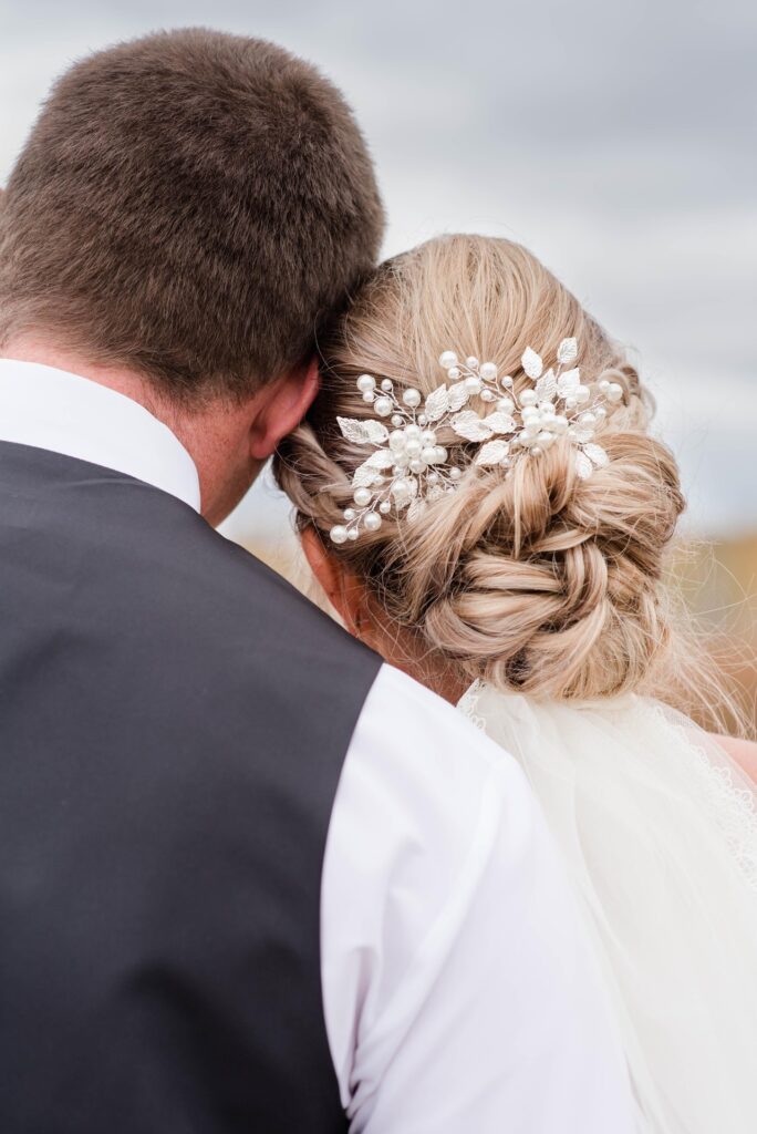 couple de marié. l mariée porte un bijoux d cheveux entourant son chignon